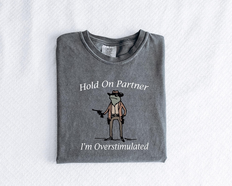 Overstimulated
Cowboy Frog
Funny Frog Shirt
Meme Tee
Frog Lover
Western Aesthetic
Cowboy Core
Yee Haw Vibes
Comfy Tee
Frog Meme
Silly Goofy Mood
Cottagecore Frog
Whimsical Fashion