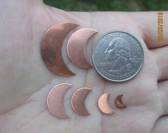 May include: A collection of six copper crescent moon shapes of varying sizes, displayed on a hand with a US quarter for scale.