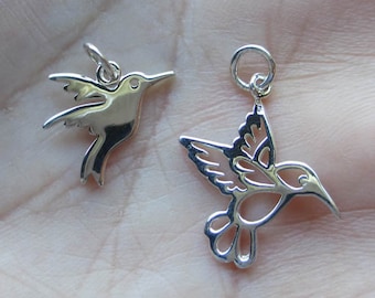 May include: Two silver hummingbird charms, one solid and one with a cut-out design.