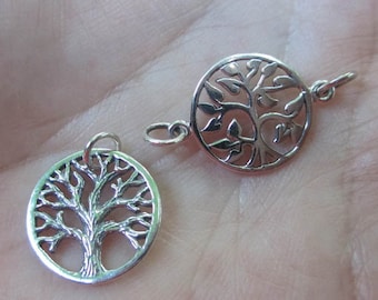 May include: Two silver tree of life charms, one with a more detailed design and the other with a simpler design. Both charms are circular and have a loop for attaching to a necklace or bracelet.
