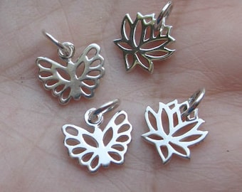 May include: Four silver charms, two are butterfly shaped and two are lotus flower shaped. The charms are delicate and intricate.
