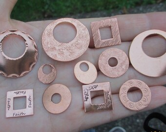 May include: A collection of ten copper metal charms with various shapes and designs, including circles, squares, and a charm with the word "Faith" inscribed on it.