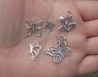 May include: Five silver butterfly charms of varying sizes. The charms are delicate and intricate, with detailed wings and bodies.