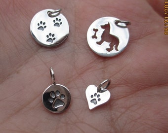Charm de plata de ley con forma de huella de pata, corazón, perro y hueso o trío de huellas de pata.
