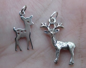 May include: Two silver deer charms, one with antlers and the other a more stylized deer with spots. Both charms have a loop for attaching to a necklace or bracelet.