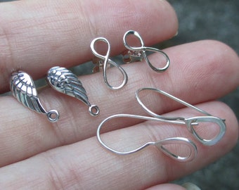 May include: A set of silver earring findings, including two wing-shaped findings, two infinity-shaped findings, and two teardrop-shaped findings.