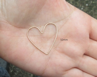 May include: A gold heart-shaped wire hoop measuring 32mm in diameter.