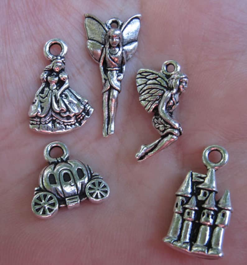 May include: Five silver charm pendants featuring fairy, princess, carriage, and castle designs. These charms are ideal for jewellery making or crafting.