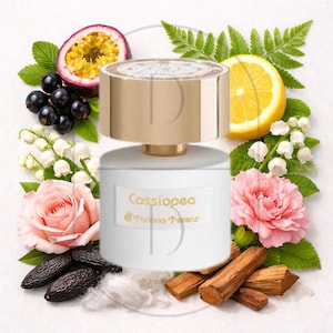 May include: A white perfume bottle with a gold cap, surrounded by passion fruit, black currants, lily of the valley, a pink rose, lemon, tonka beans, wood, and cotton. The bottle has the name "Cassiopea" on it.