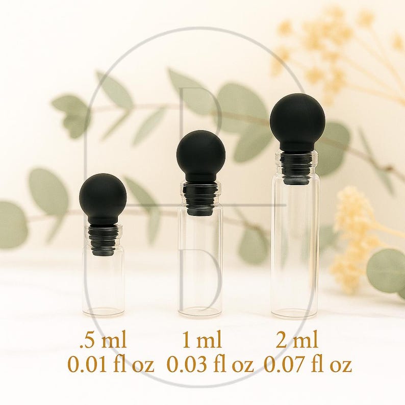 May include: Three clear glass bottles with black stoppers. The bottles are labeled with measurements: .5 ml, 1 ml, and 2 ml, and also with fluid ounces: 0.01 fl oz, 0.03 fl oz, and 0.07 fl oz. The bottles are arranged in a row.