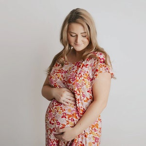 Plus Size pregnant mom wearing pink floral hospital delivery gown to deliver baby. Fabric is soft and stretch with snaps at shoulder for breastfeeding and down back for epidural. Long enough to cover knees. Favorite baby shower gift from sister.