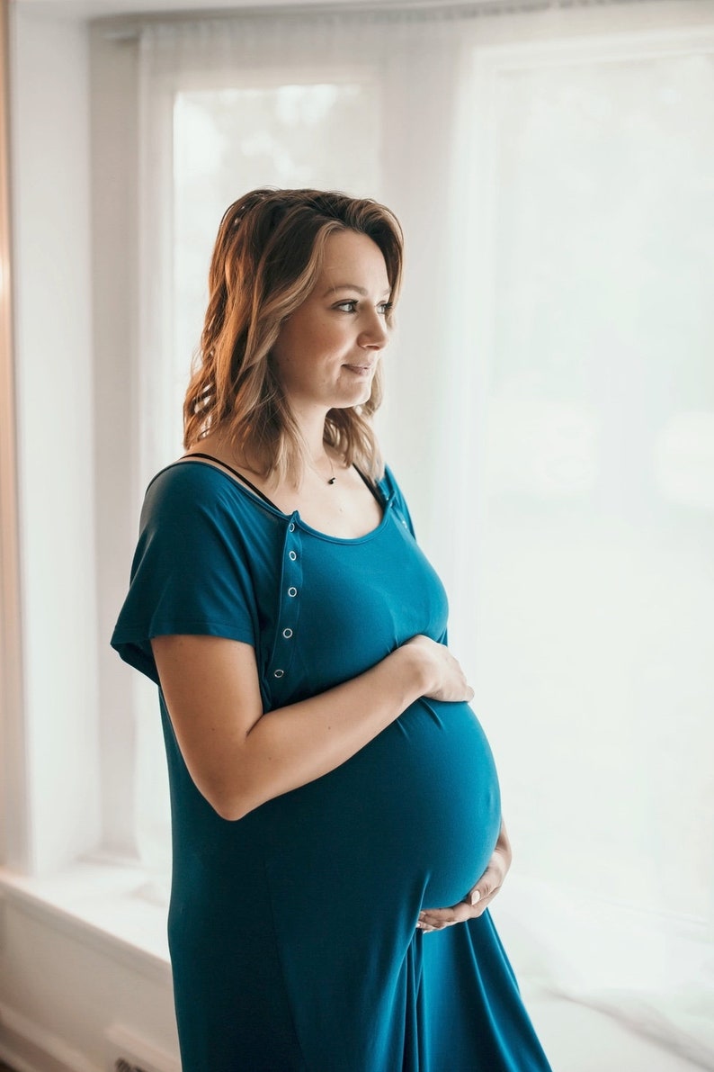 Plus Size pregnant mom wearing dark blue hospital delivery gown to deliver baby. Fabric is soft and stretch with snaps at shoulder for breastfeeding and down back for epidural. Long enough to cover knees. Favorite baby shower gift from neighbor.