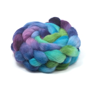 May include: A thick, braided bundle of soft wool roving featuring a vibrant gradient of colors including deep navy blue, royal blue, bright turquoise, lime green, and soft lavender, arranged in a circular, coiled, and textured fiber formation.