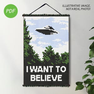 May include: A cross-stitch wall hanging with a pixelated image of a UFO flying over a forest. The text "I WANT TO BELIEVE" is below the UFO.