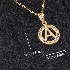 May include: A gold pendant necklace with a circular pendant featuring the letter A surrounded by clear rhinestones. The pendant is 0.45 inches in height and width. H=0.45inch W=0.45inch