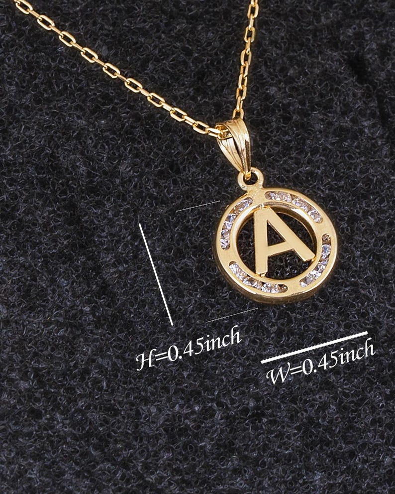 May include: A gold pendant necklace with a circular pendant featuring the letter A surrounded by clear rhinestones. The pendant is 0.45 inches in height and width. H=0.45inch W=0.45inch