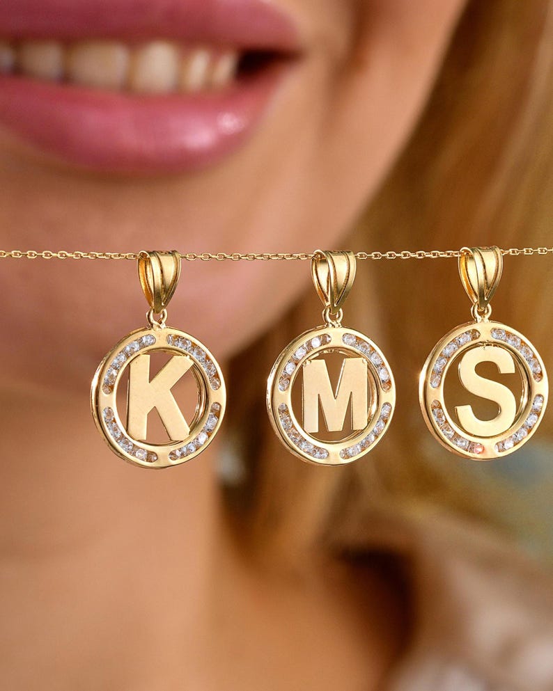 0.7inch diameter 14K gold initial letter pendants are on the gold necklace lined together. K, S,,L initials are on the picture for sampling.
Also, on the same necklace, 0.45inch smaller (variation) type of  K initial is shown for scaling.
