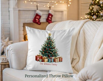 May include: White throw pillow featuring a watercolor Christmas tree decorated with ornaments and topped with a gold star. Presents are at the base of the tree. The text "The Williams Family" is below the tree. The words "Personalized Throw Pillow" are at the bottom.