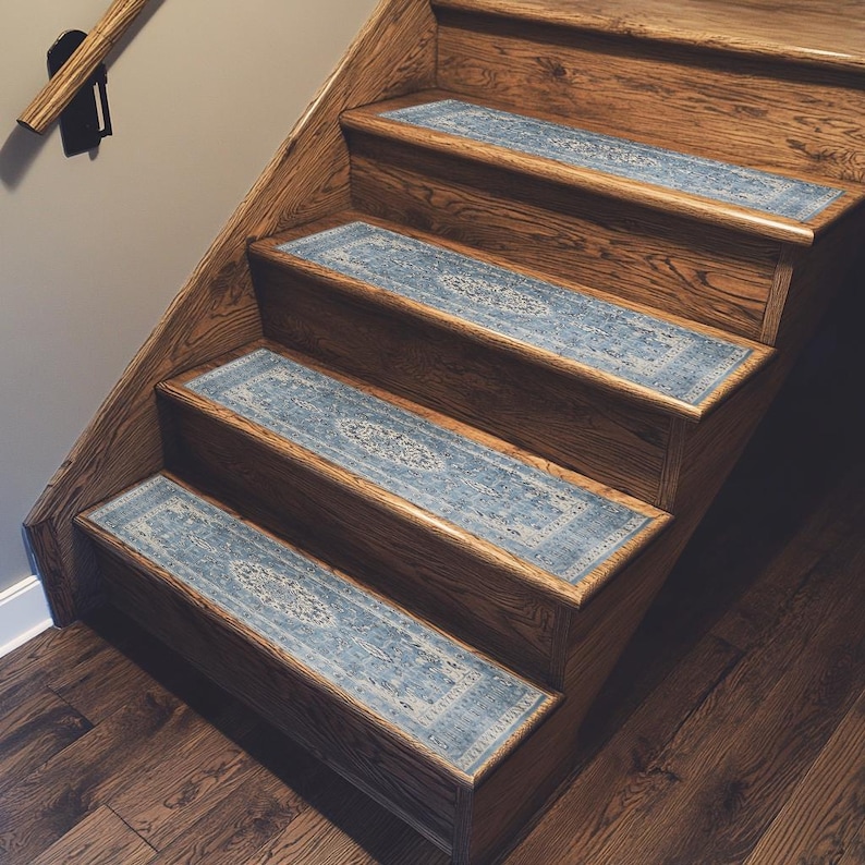 a set of wooden stairs with blue and white patterned carpet runners on each step, leading up to a higher level.