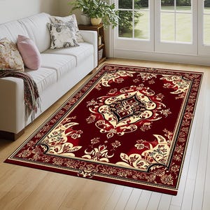 Könnte beinhalten: Ein roter Teppich mit einem goldenen und schwarzen Blumenmuster. Der Teppich hat einen detaillierten Rand mit einem sich wiederholenden Muster.