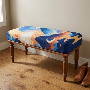 May include: A rectangular upholstered bench with four turned wooden legs. The seat features a printed fabric design depicting a night sky with a crescent moon, stars, and abstract cloud shapes in shades of deep blue, orange, and cream.