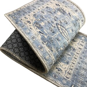 a close-up view of a blue and white patterned rug or carpet with a geometric design.