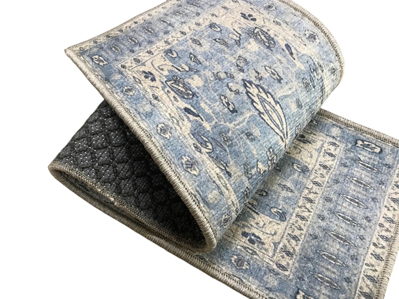 a close-up view of a blue and white patterned rug or carpet with a geometric design.