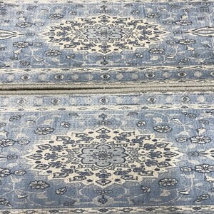 a close-up view of a blue and white patterned rug or carpet with intricate designs and floral motifs.