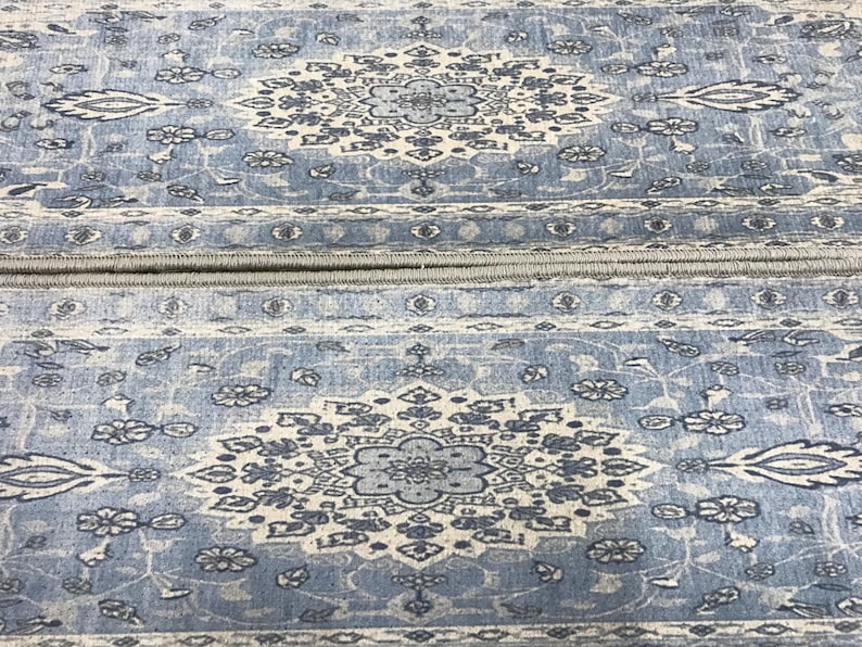 a close-up view of a blue and white patterned rug or carpet with intricate designs and floral motifs.