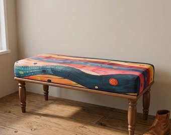 Op de afbeelding: Een rechthoekige gestoffeerde bank met een levendig patroon van golvende horizontale strepen in tinten blauwgroen, oranje, rood en geel, geaccentueerd met kleine cirkelvormige motieven, ondersteund door vier gedraaide houten poten in middenbruin.