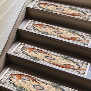 May include: Stair treads with a beige and blue oriental rug design featuring a tiger. The treads have a rectangular shape with a cream border and are placed on wooden stairs. The tiger is orange and black.