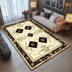May include: A cream-colored rug with a black and gold geometric pattern. The pattern features a diamond shape with a floral design in the center. The rug has a black border with a gold floral design.