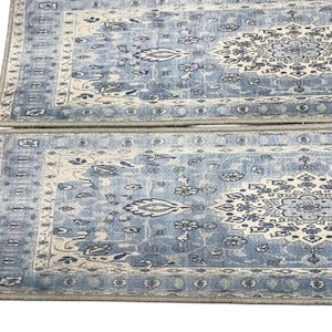 two blue and white patterned area rugs placed side by side on a white background.
