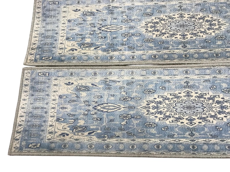 two blue and white patterned area rugs placed side by side on a white background.