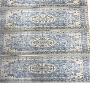 a collection of four identical blue and white patterned rugs arranged in a row.