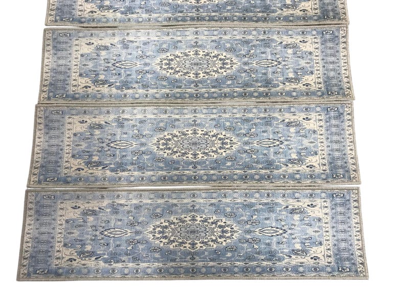 a collection of four identical blue and white patterned rugs arranged in a row.