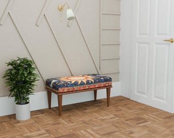 May include: A rectangular bench featuring a dark blue upholstered seat with a vibrant sun, moon, and star pattern. The bench is supported by four tapered wooden legs in a medium brown finish, providing a stable base for the patterned cushion.