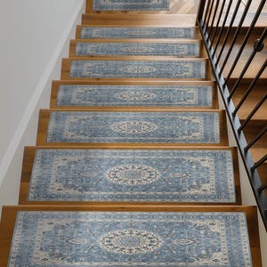 A set of wooden stairs with blue and white patterned rugs on the steps leading up to a staircase.