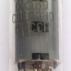 Peut inclure: Gros plan d'un tube à vide vintage avec des composants internes visibles. Le tube porte les inscriptions "69", "CCCP" et du texte cyrillique. Le tube est enfermé dans du verre transparent.