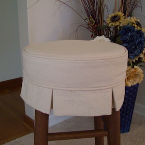 Peut inclure: Housse de tabouret en tissu blanc avec un volant pliss&eacute; autour du bas. La housse est faite d'un tissu doux et naturel, id&eacute;ale pour prot&eacute;ger votre tabouret des &eacute;claboussures et des taches.