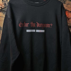 May include: Black sweatshirt with a red graphic that says "Enter the dungeon?" with two buttons that say "Yes" and "Run".