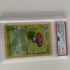 Puede incluir: Una carta coleccionable Pok&eacute;mon Jungle 1st Edition Vileplume Holo de 1999, en un protector. La carta presenta una ilustraci&oacute;n de Vileplume con un dise&ntilde;o de hongo rojo y gris. La carta est&aacute; calificada NM-MT 8.