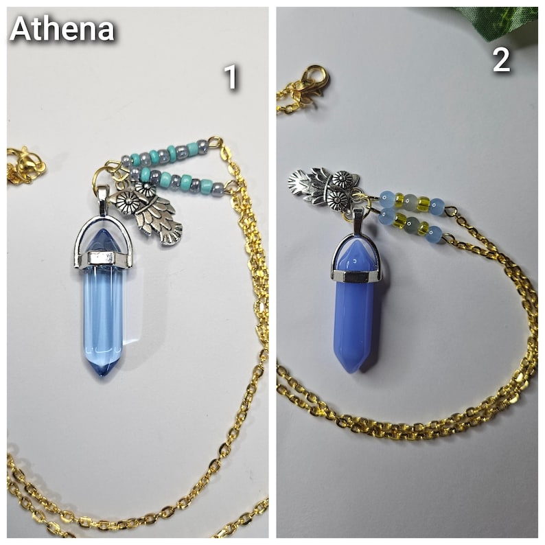 Puede incluir: Dos collares etiquetados como Athena 1 y 2. Cada uno cuenta con una cadena dorada, un dije de b&uacute;ho plateado y un colgante de cristal puntiagudo. El collar 1 tiene un cristal azul transl&uacute;cido y cuentas turquesas. El collar 2 tiene un cristal azul mate y cuentas azul claro.