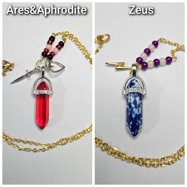 Puede incluir: Dos collares con cadenas doradas. El collar izquierdo, etiquetado Ares&Aphrodite, presenta un colgante de cristal rojo, un dije de espada plateada, un coraz&oacute;n y cuentas negras y rosas. El derecho, etiquetado Zeus, tiene un colgante de cristal azul y blanco, un dije de rayo dorado y cuentas moradas y blancas.