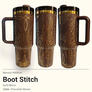 Puede incluir: Tres tazas de viaje marrón chocolate con diseños de costura de bota dorada. Cada taza tiene un asa, una tapa negra y adornos dorados. El texto "Boot Stitch" es visible debajo.