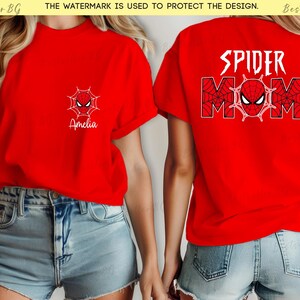 Puede incluir: Camisetas rojas con tem&aacute;tica de Spider-Man. Una camiseta tiene un peque&ntilde;o dise&ntilde;o de telara&ntilde;a y m&aacute;scara con el nombre "Amelia". La otra camiseta tiene "SPIDER MOM" impresa en la espalda, con un dise&ntilde;o de telara&ntilde;a y m&aacute;scara.