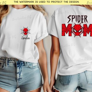 Puede incluir: Camisetas blancas con tem&aacute;tica de Spider-Man. Una camiseta tiene un peque&ntilde;o logo de Spider-Man y el nombre "Amelia". La otra muestra "SPIDER MOM" en rojo y negro, con un logo de Spider-Man. Ambas son de manga corta.