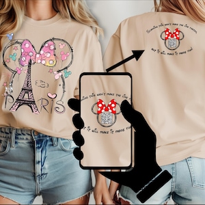 Op de afbeelding: Beige T-shirt met een Minnie Mouse-ontwerp met de Eiffeltoren en het woord "PARIS". Het ontwerp bevat een roze strik met stippen en kleurrijke accenten. De achterkant van het shirt heeft een bijpassend ontwerp met de tekst "Scannen maakt de rij niet sneller, maar wel leuker!"