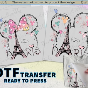 Op de afbeelding: DTF-transfer met een zwarte Eiffeltoren, Mickey Mouse oren en het woord "PARIS". Het ontwerp bevat kleurrijke ballonnen, sterren en een roze strik. De tekst "DTF TRANSFER READY TO PRESS" is ook zichtbaar.