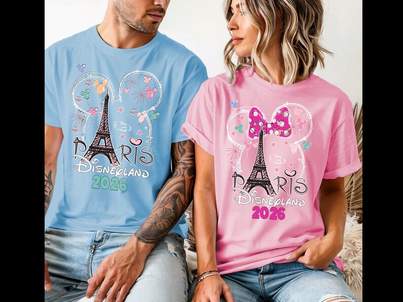 May include: Light blue and pink t-shirts with a graphic of the Eiffel Tower, Mickey Mouse ears, and the text "Paris Disneyland 2026." The shirts are short-sleeved and feature a whimsical design.